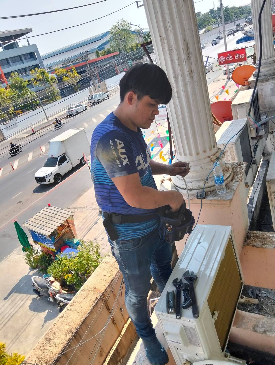 ติดตั้ง/ซ่อมคอยล์เย็นริมระเบียงอาคารติดถนน