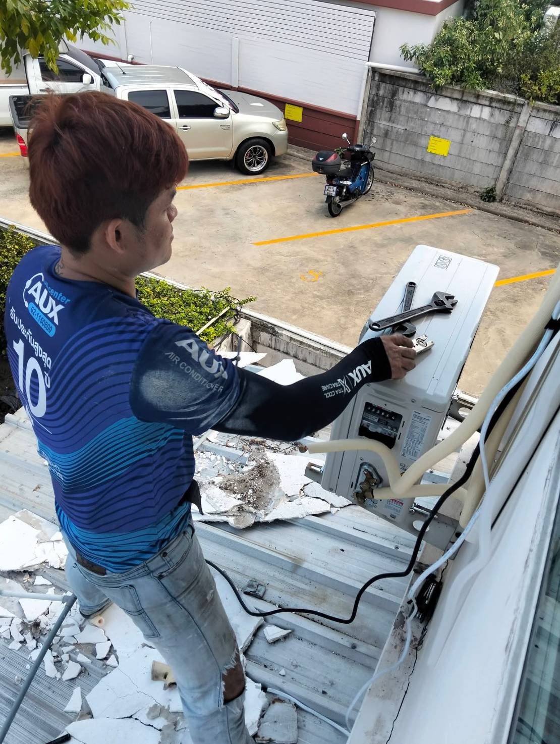 ถอดซ่อมคอยล์ร้อนแอร์ AUX ที่ผนังภายนอก